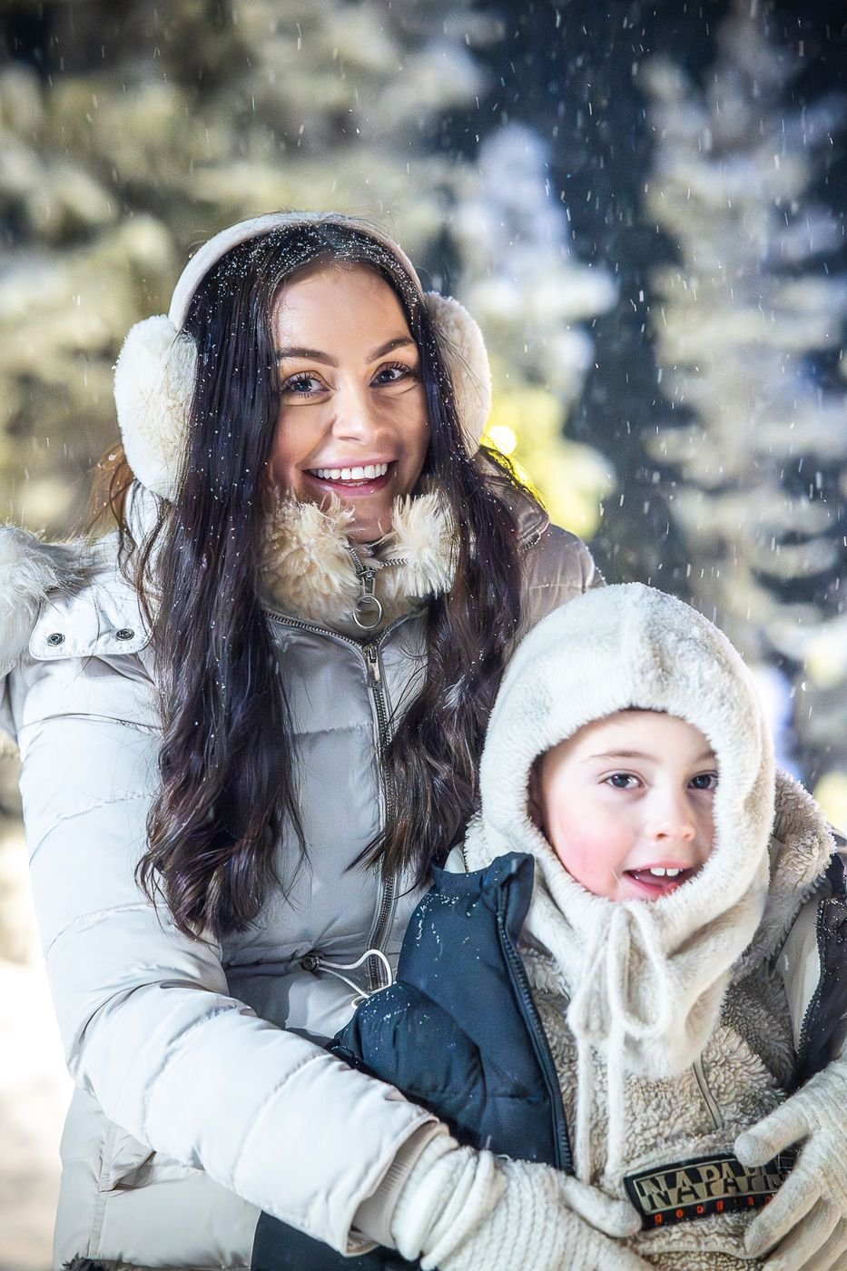 Mother and child smiling in falling snow in Lapland